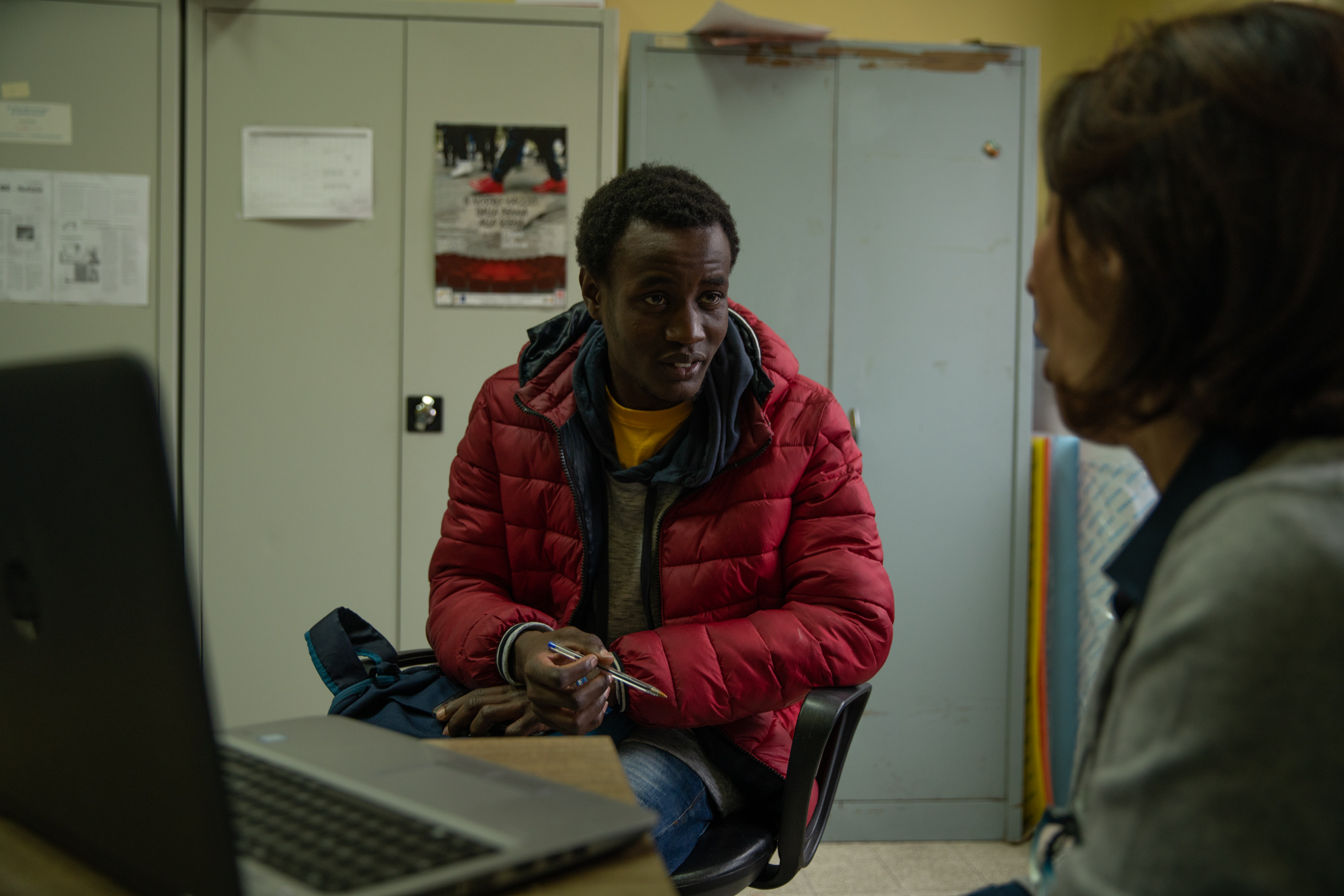 Fidèle discusses biology homework with his teacher, Milena, in the staff office at the Battisti Foscolo Adult Education Center.<br />
<br />
